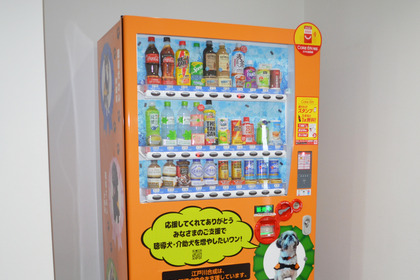 江戸川合成、聴導犬・介助犬支援のためのラッピング寄付型自動販売機を設置 画像